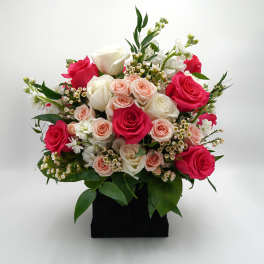 Bouquet of pink and white roses in a black box vase