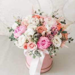 Pink and white bouquet in a round pink box with a white ribbon