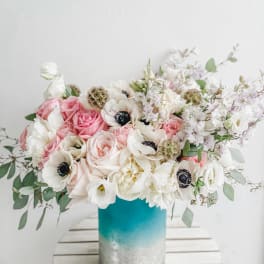 Pink and white flowers arranged in a blue vase