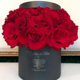 Red roses arranged in a black round hat box