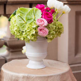 Pink and white roses with green hydrangeas in a white vase