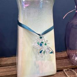 Decorative iridescent glass bottle with a blue ribbon and butterfly charm