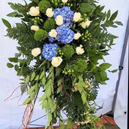Tall floral standing spray with blue hydrangeas and white roses
