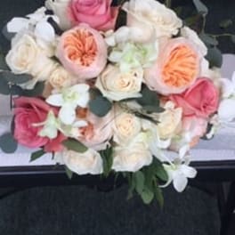 Bouquet of pink, white, and peach roses with white orchids