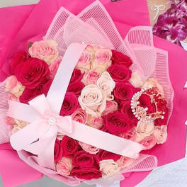 Bouquet of pink and red roses wrapped in bright pink paper