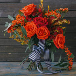 Bouquet of orange and red roses with a striped ribbon