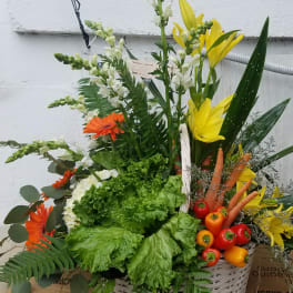 Basket arrangement with yellow lilies, orange gerberas, and vegetables
