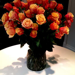 Bouquet of orange and peach roses in a glass vase