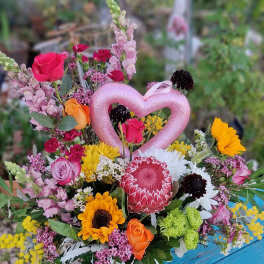 Mixed bouquet with roses, sunflowers, and a pink heart pick