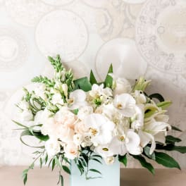 White floral arrangement in a square glass vase