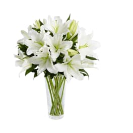 White lilies arranged in a clear glass vase