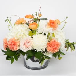 Peach and white floral arrangement in a clear glass vase