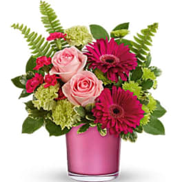 Pink roses and magenta daisies in a pink glass vase