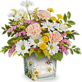 Mixed bouquet of daisies, carnations, and yellow filler flowers in a painted glass vase