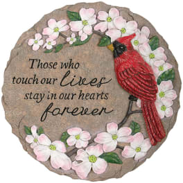 Round memorial plaque with pink flowers and a red cardinal