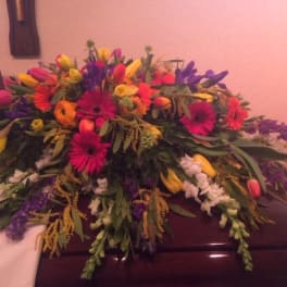 Colorful floral casket spray with gerbera daisies and tulips