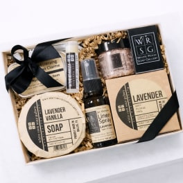 Gift box with lavender soap, spray, scrub, and balm tied with black ribbon