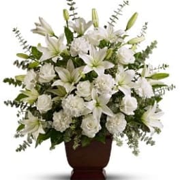 White lilies and roses arranged in a dark vase