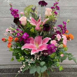 Mixed bouquet with pink lilies and roses in a glass vase