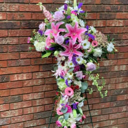 Tall cross-shaped floral spray with pink lilies and mixed blooms