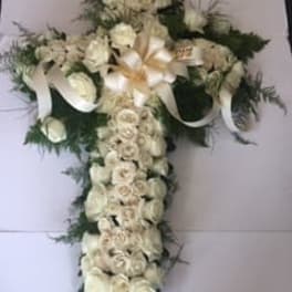 White floral cross arrangement with ribbon accents