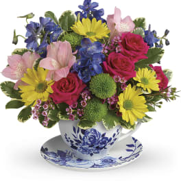Colorful bouquet in a blue-and-white teacup with saucer