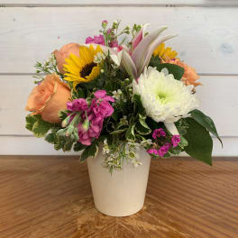 Mixed bouquet in a white vase with sunflowers, roses, and white chrysanthemum