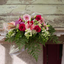 Mixed bouquet of pink and white flowers wrapped in clear plastic