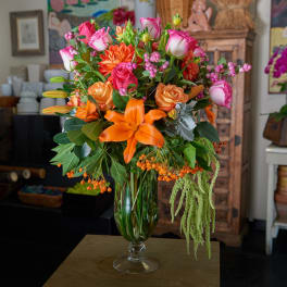 Mixed bouquet of orange lilies and pink roses in a glass vase