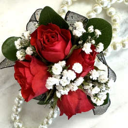Red rose corsage with white baby's breath and pearl accents