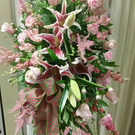 Tall pink and white floral spray with lilies and roses on a stand