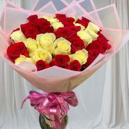 Bouquet of red and pale yellow roses wrapped in pink paper