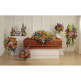 Colorful funeral casket spray with standing floral arrangements