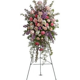 Tall standing floral spray with pink and lavender flowers on a metal easel