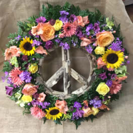 Floral peace sign wreath with sunflowers, roses, and purple blooms