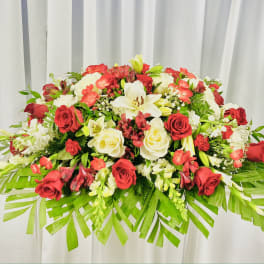 Large red and white floral arrangement with palm fronds