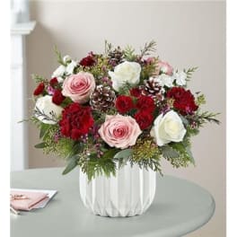 Bouquet of pink and white roses with red carnations in a white vase