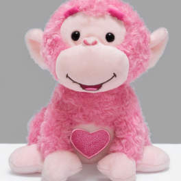 Pink plush monkey holding a heart
