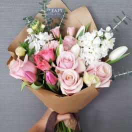 Hand-tied bouquet of pink and white roses with tulips and white blooms
