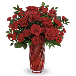 Red roses and carnations in a red glass vase