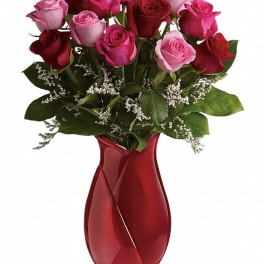 Bouquet of pink and red roses in a red glass vase
