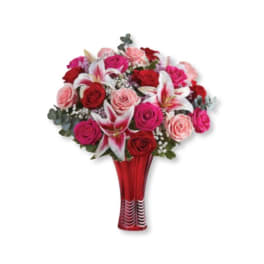 Bouquet of red, pink, and white flowers in a red vase