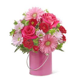 Pink roses and daisies arranged in a pink metal container