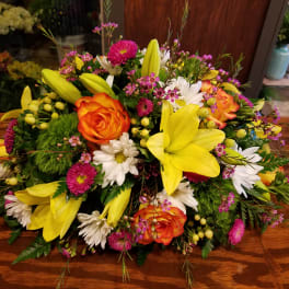 Bright mixed bouquet with yellow lilies, orange roses, and white daisies