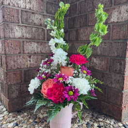 Mixed bouquet in a pink pitcher vase with white, pink, and purple flowers