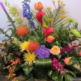 Colorful tropical flower arrangement with spiky blooms and roses
