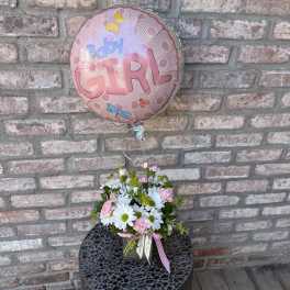 Baby girl balloon with pink and white daisy arrangement in a glass cube vase