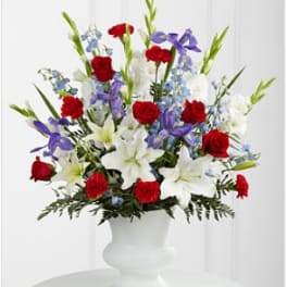Red roses, white lilies, and purple flowers in a white vase