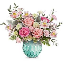Pink and white mixed flower arrangement in a turquoise glass vase