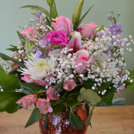 Pink and white mixed bouquet in a red glass vase